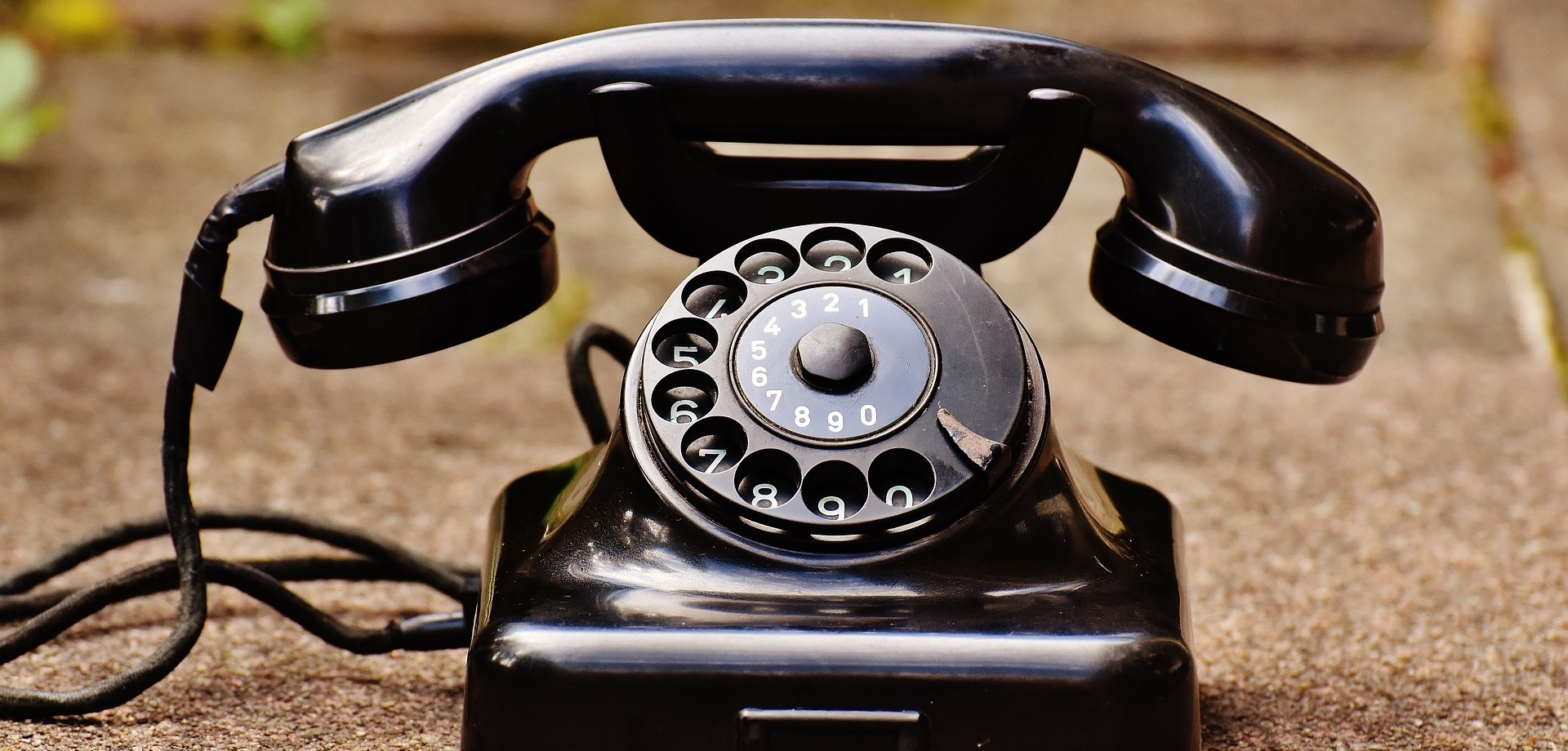 Ein altes, schwarzes Wählscheibentelefon.
